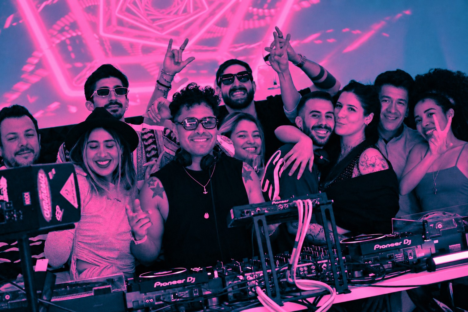 Foto de grupo en la cabina de Sunny Grooves, con tratamiento cyan y rosa